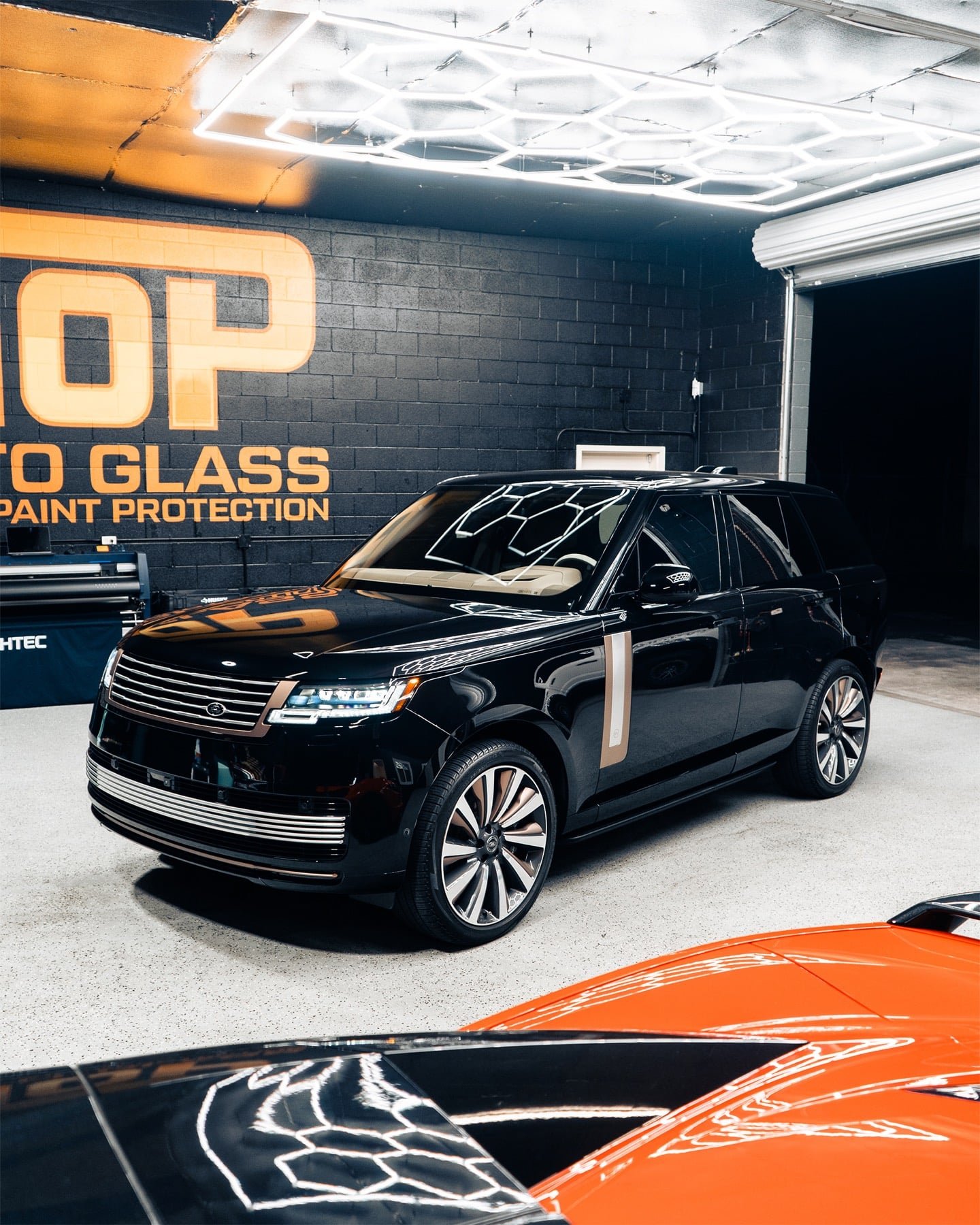 Black Range Rover inside the Top Auto Glass shop in Clovis under hexagon LED lighting